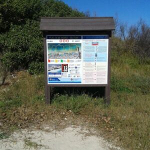 Cartel informativo ecológico con tejado de plástico reciclado en naturaleza frente al mar